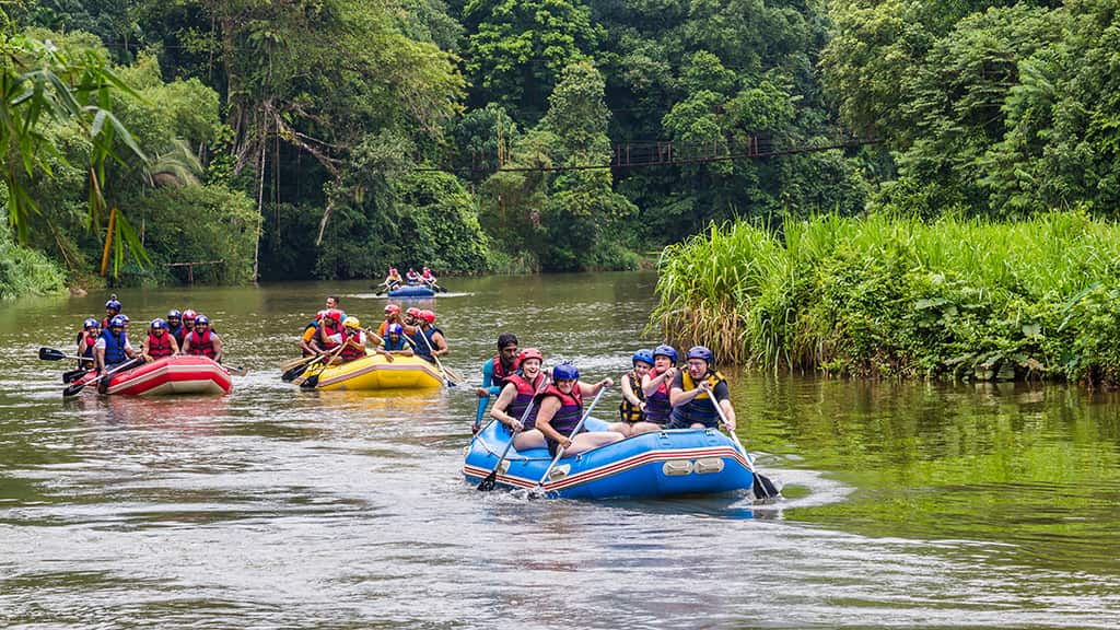 Group of white water rafters cheering and happily posing