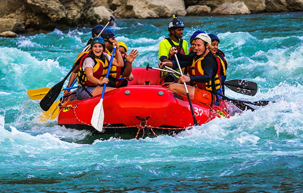 Group of white water rafters cheering and happily posing