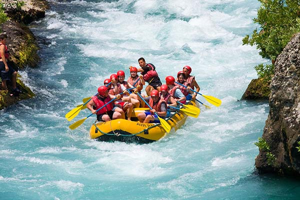 Group of white water rafters cheering and happily posing