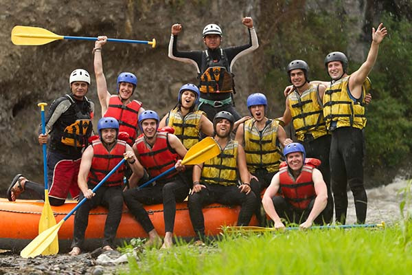 Group of white water rafters cheering and happily posing